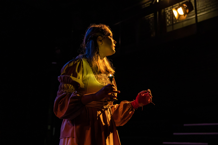 Actor on stage under red and yellow lighting